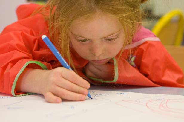 Jeune fille en situation de handicap en train de dessiner