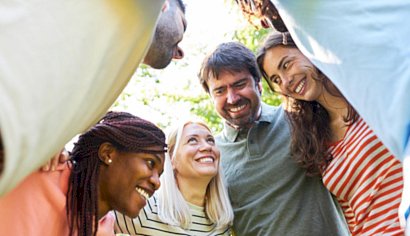 Groupe de personnes souriantes réunies en rond