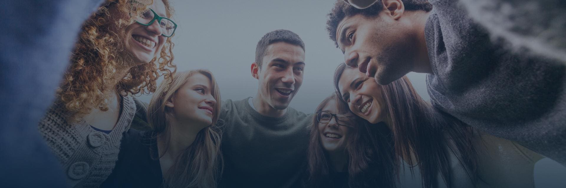 Groupe d'amis de toutes origines enlacés en formant cercle