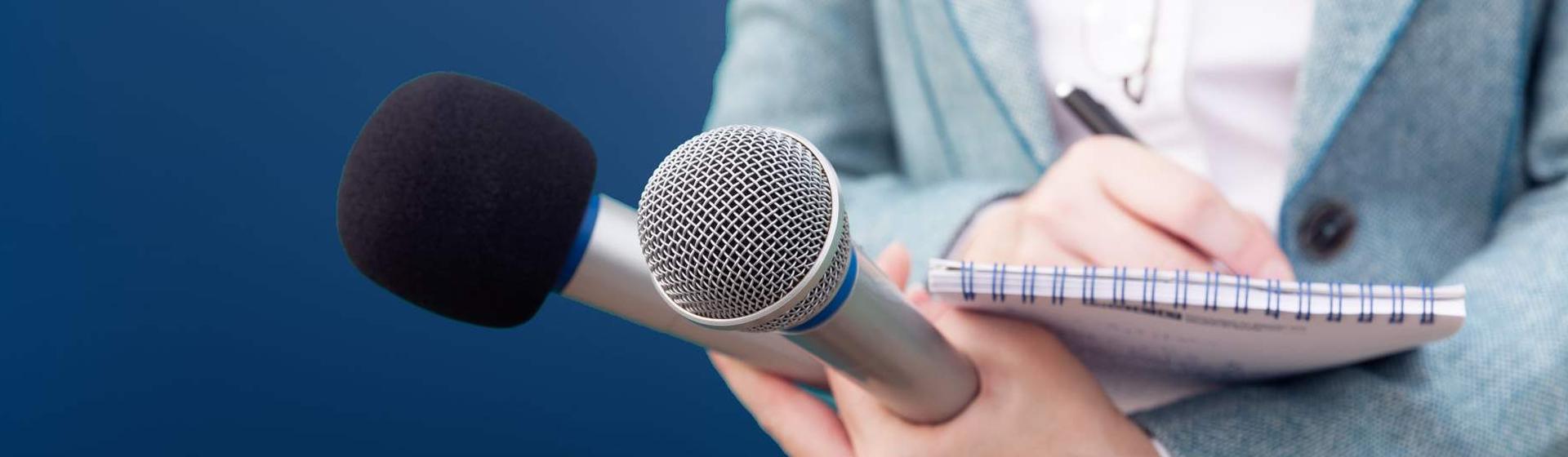 Journaliste prend des notes dans l'espace presse GMF