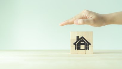 Maison protégée par une main au dessus d'elle