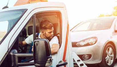 Handsome middle age man working in towing service on the road. Roadside assistance concept.