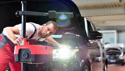 Lichttest // Automotive mechanic makes light test in workshop