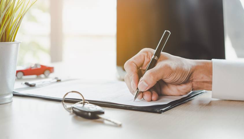 client qui remplit un document à fournir pour assurer une voiture