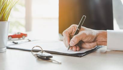client qui remplit un document à fournir pour assurer une voiture