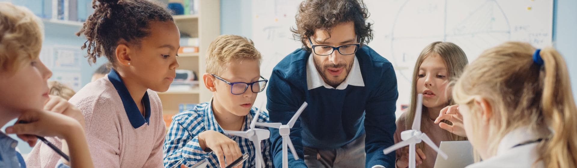 Teacher and pupils working at desk together