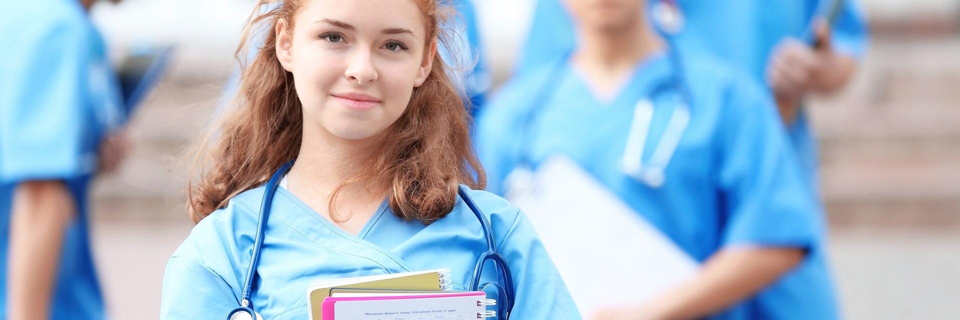 Jeune élève infirmière avec ses cahiers dans les bras