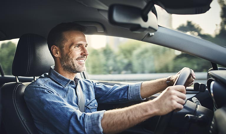Homme au volant de sa voiture assuré avec l'assurance auto GMF