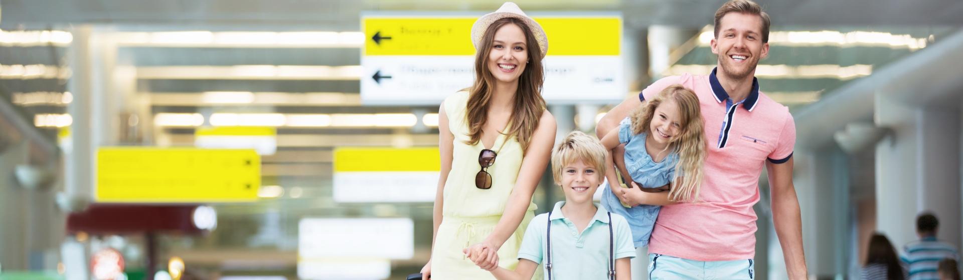 Famille heureuse à l'aéroport a souscrit l'Assurance Voyage GMF