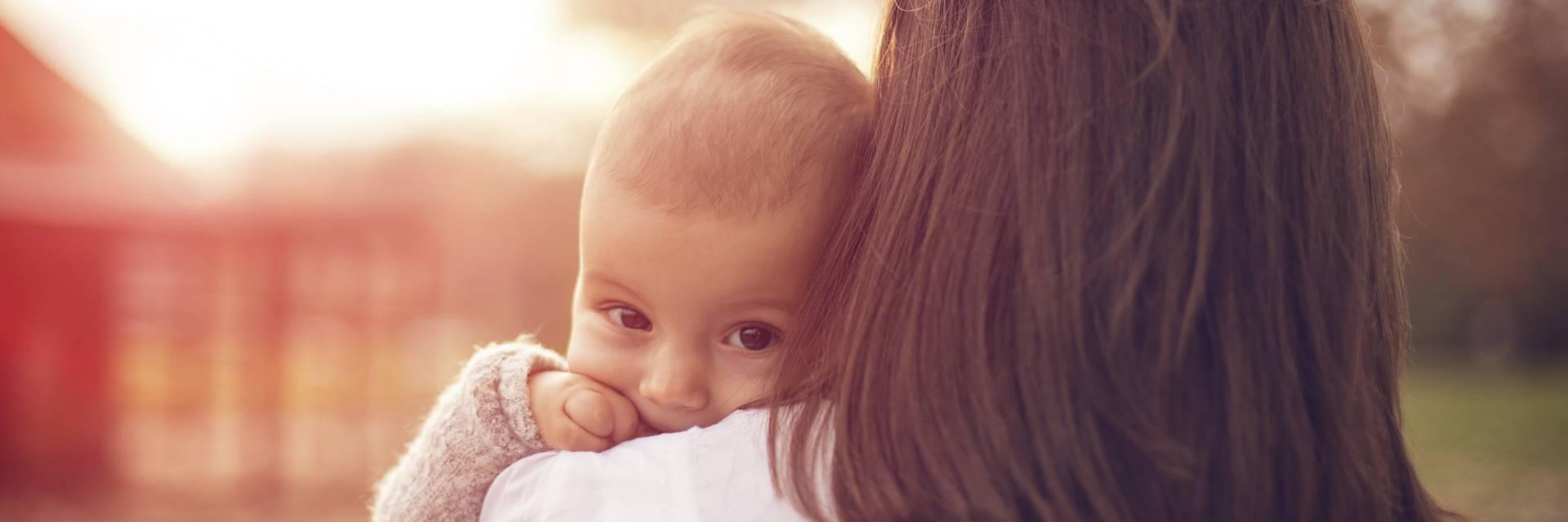 Jeune maman portant son enfant dans les bras prévoit de réaliser une simulation d'investissement sur l'assurance vie MULTÉO