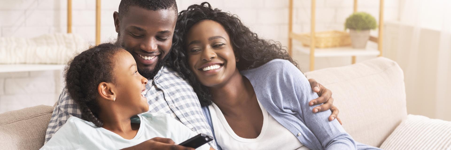 Le père, la mère et leur fille se regardent en souriant