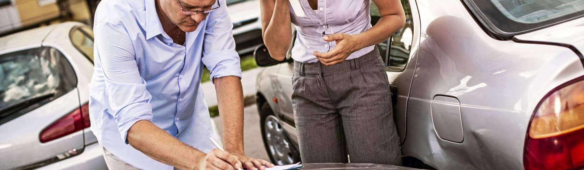 homme et femme en train de remplir un constat amiable