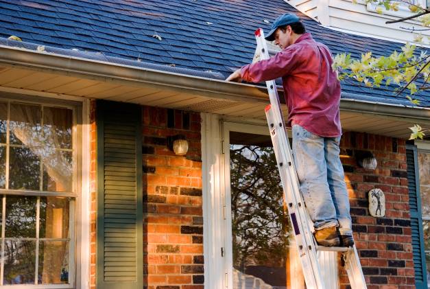 Personne qui fait des travaux sur sa toiture