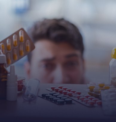 Sick ill man looking for medicines at farmacy shelf