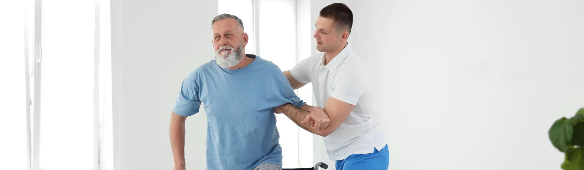 Professional physiotherapist working with senior patient in rehabilitation center